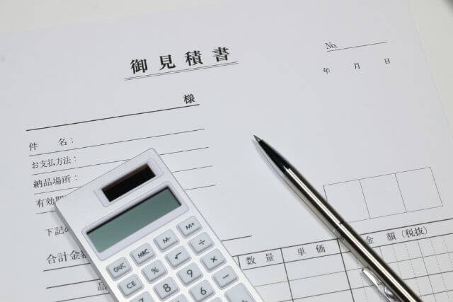 見積書とペンと電卓の並んだ机