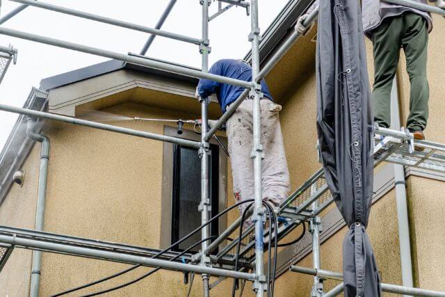 外壁塗装中の作業員と足場